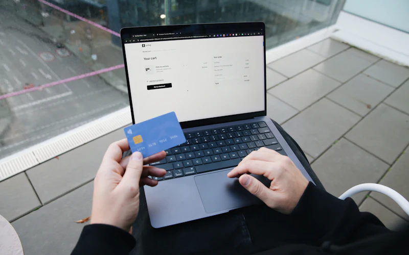 Person paying online with a credit card on a laptop